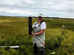 Nicole Maher poses with a salt marsh core sample.
