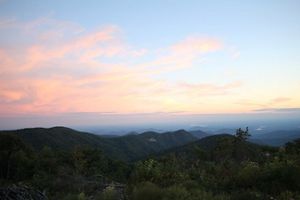 The sun sets over a mountain range.