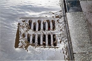 Water flowing over a storm drain.