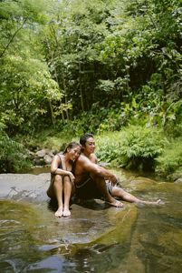 Two volunteers relax next to He'eia Stream.