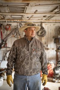  Man in camo stands in shed