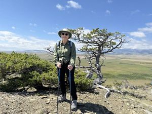 A woman enjoying a hike with hiking sticks. 