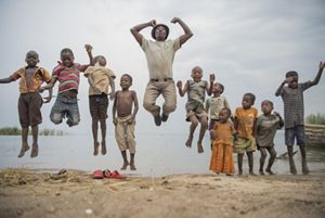 The Nature Conservancy's Peter Limbu plays with children next to Lake Tanganyika, Tanzania.