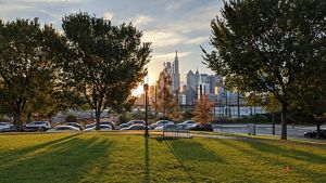 A park at sunset with the Philadelphia skyline in the background. 
