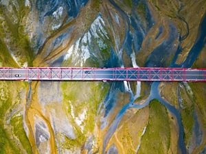 Aerial view looking straight down on a bridge that crosses a wide river.