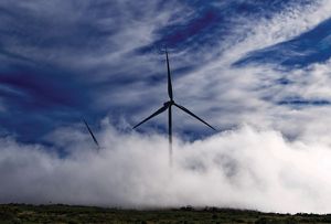 Photo of two wind turbines emerging from fog on the Paul da Serra plateau, Madeira, Portugal.