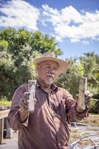 Marcos Ruiz holds up two Montezuma cypress seedlings.