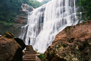 Person standing in front of waterfall