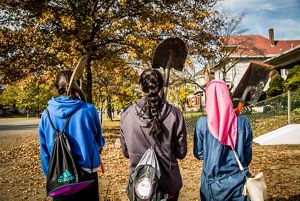 Three young girls walk with garden tools