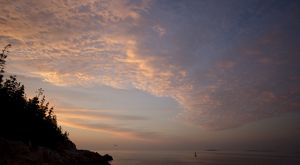 Pink clouds light an evening nearshore ocean scene.