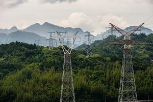 View of high voltage power lines on a mountain range.