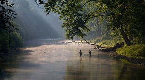 Dos pescadores dentro de un río