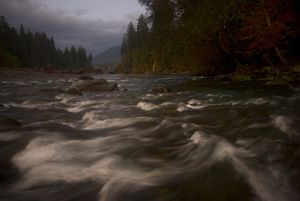 Time-lapse image of a rushing river running over rocks and boulders.