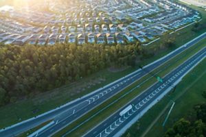toll highway next to cookie cutter housing development 