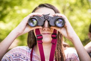 Joven observa por binoculares