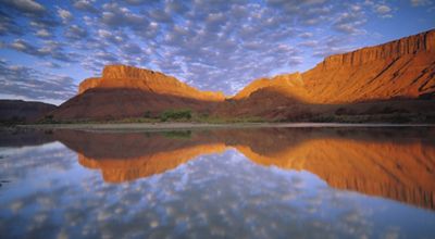 Montanas rojizas y reflejos de cielo azul en el rio Colorado en Utah.