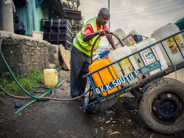 Man filling up water containers in Nairobi, Kenya.