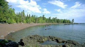 The Lake Superior shoreline lined by trees at Horseshoe Harbor in Michigan's Keweenaw Peninsula.