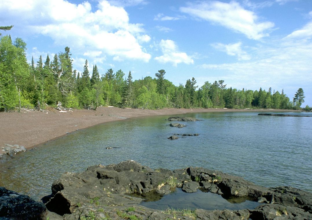 The Lake Superior shoreline lined by trees at Horseshoe Harbor in Michigan's Keweenaw Peninsula.