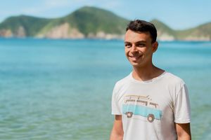 Tomás Pinzón stands outside in front of a large body of water.
