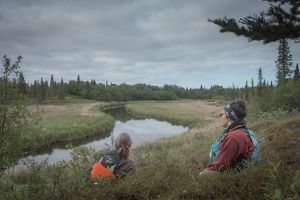 Mary Hostetter and Bill Kane relax along the grassy shores of a stream.