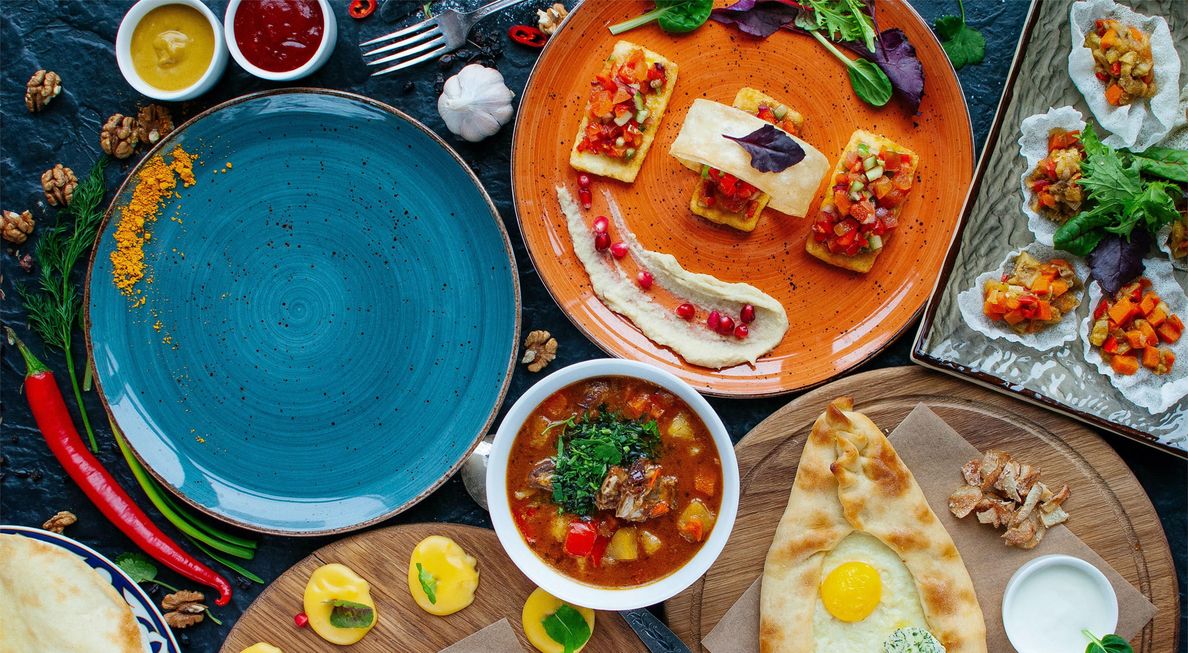 a brightly colored spread of food and plates on a table