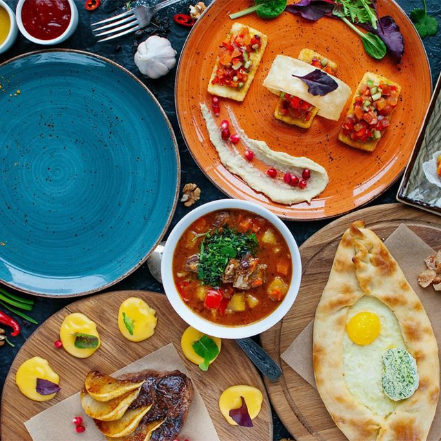 a spread of brightly colored food and dinner plates on a table