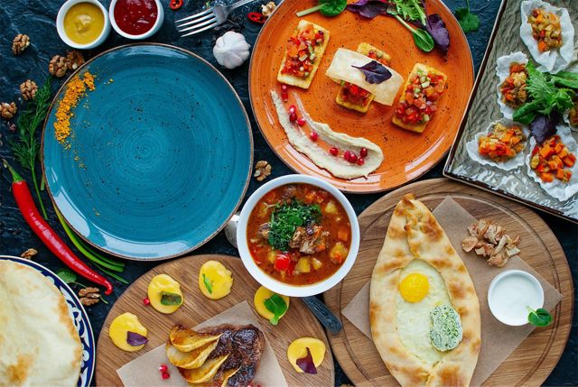 an overhead shot of a colorful table filled with plates of different types of food