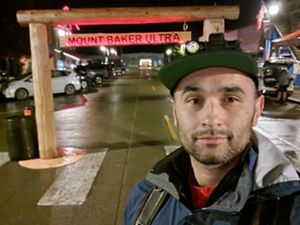 A person selifies in front of a sign that reads Mount Baker Ultra.
