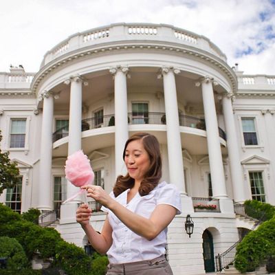 Jennifer Lee Clinchy stands outside the White House and eats cotton candy.