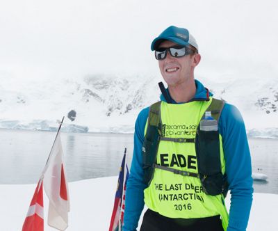 Kyle McCoy stands in front of a lake in a snowy area.