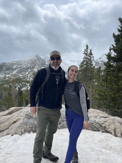 Paul Jewell and a young woman stand together on top of a mountain.