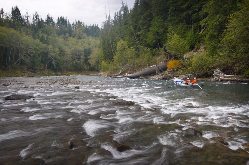Two people ride a dory down the Hoh River in Washington state.