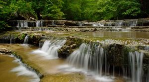 Waterfalls spread across a creek.
