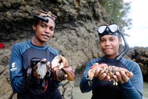 Generasi muda Kelompok Sasi Perempuan Waifuna, Yolanda Kacili (kiri) dan Yonance Hay (kanan), bersama hasil tangkapan mereka pada buka sasi di Kampung Kapatcol, Distrik Missol Barat, Kabupaten Raja Ampat, Provinsi Papua Barat Daya, Senin, 25 Maret 2024.