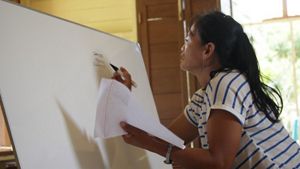 Marsiti dan anggota masyarakat Dayak Mapnan Long Duhung sedang mempelajari praktik administrasi sederhana bersama YKAN.