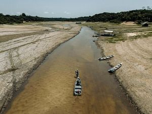 Período de seca níveis baixos de água tornaram intransitáveis os rios próximos a São Francisco de Marina, no Brasil. Um homem puxa seu barco por algumas das áreas mais rasas.